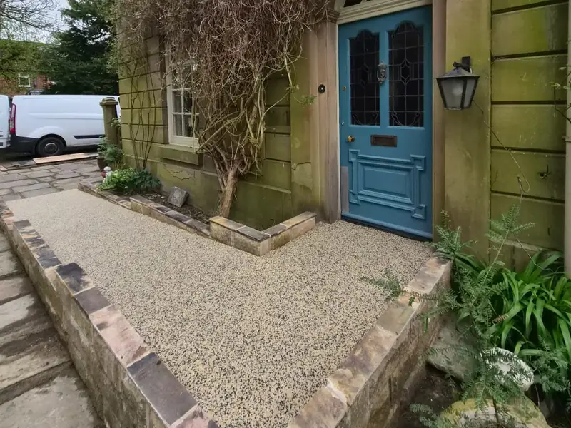 Resin bound front path inside sandstone walls leading to a period front door