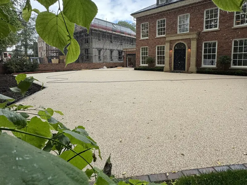 Large cream resin bound driveway and forecourt in front of a Georgian style brick house